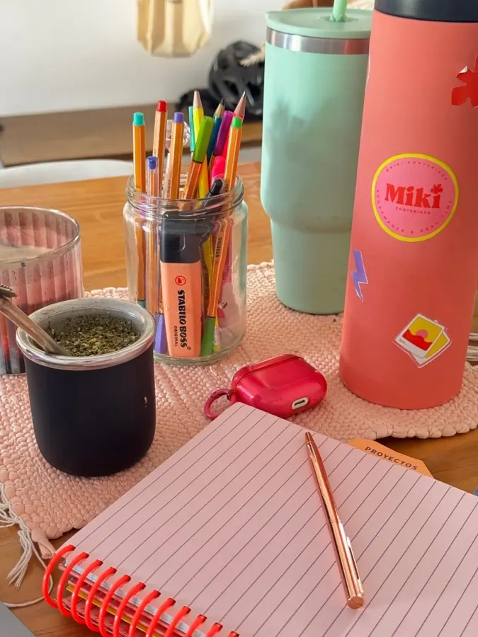 Mesa de trabajo con cuaderno, marcadores y mate